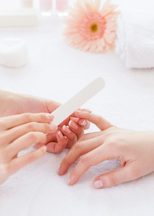 Polishing female nails. Close-up of beautician polishing nails of female customer